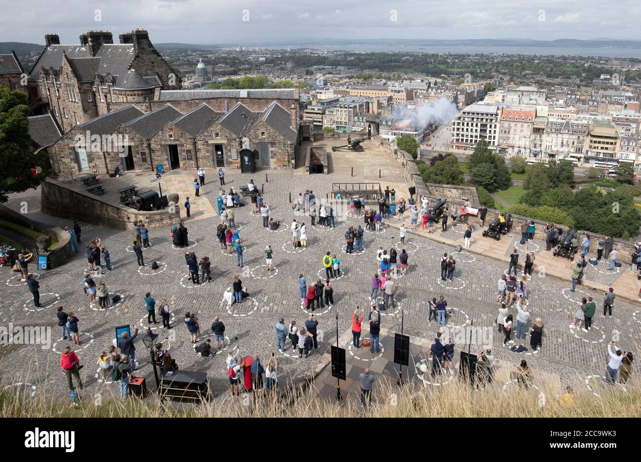 Visitors At Edinburgh Castle Stand Socially Distanced In Marked Out Circles As They Watch The Daily One O Clock Gun Ceremony As Scotland Continues In Phase 3 Of Coronavirus Lockdown Restrictions Stock Photo