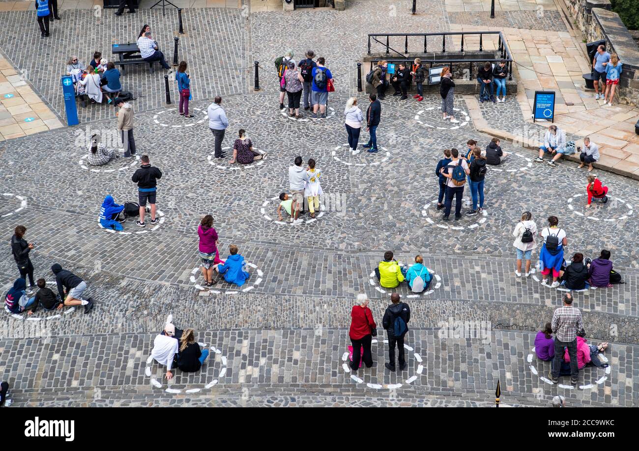 Visitors At Edinburgh Castle Stand Socially Distanced In Marked Out Circles As They Watch The Daily One O Clock Gun Ceremony As Scotland Continues In Phase 3 Of Coronavirus Lockdown Restrictions Stock Photo