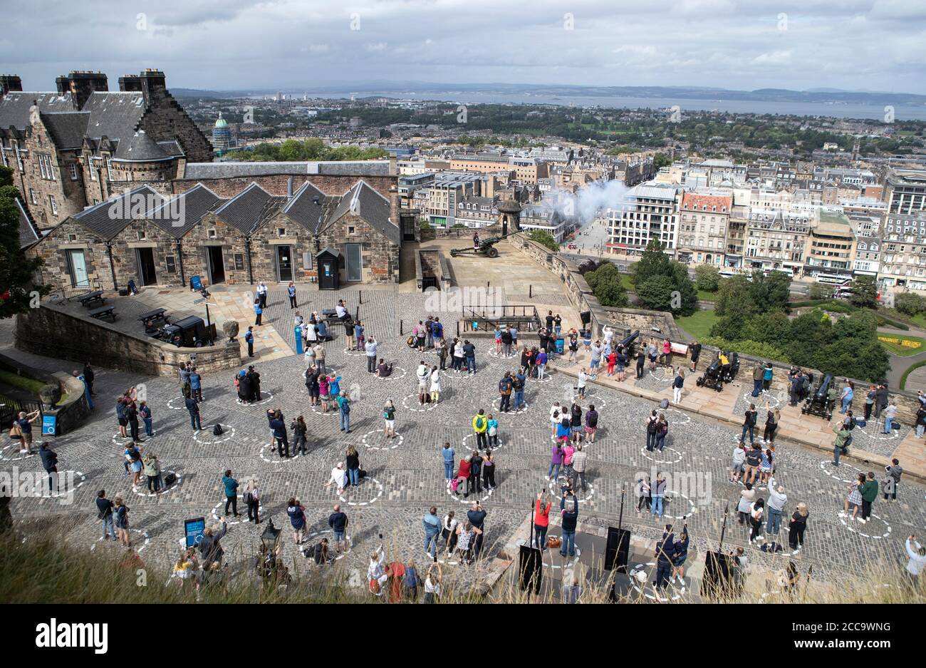 Visitors At Edinburgh Castle Stand Socially Distanced In Marked Out Circles As They Watch The Daily One O Clock Gun Ceremony As Scotland Continues In Phase 3 Of Coronavirus Lockdown Restrictions Stock Photo