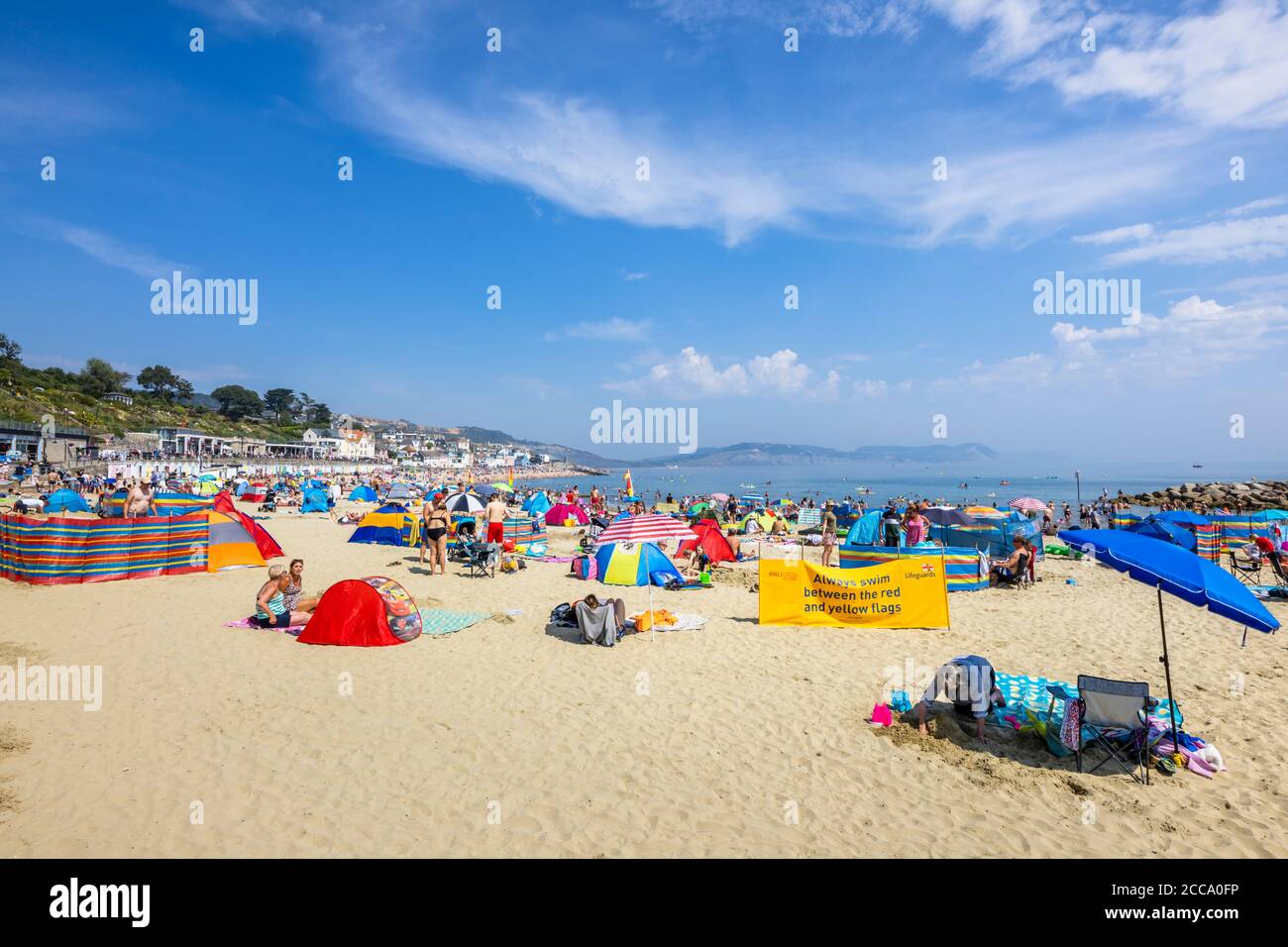 The crowded beach and seafront in high season at Lyme Regis, a popular seaside holiday resort on the Jurassic Coast in Dorset, south-west England Stock Photo