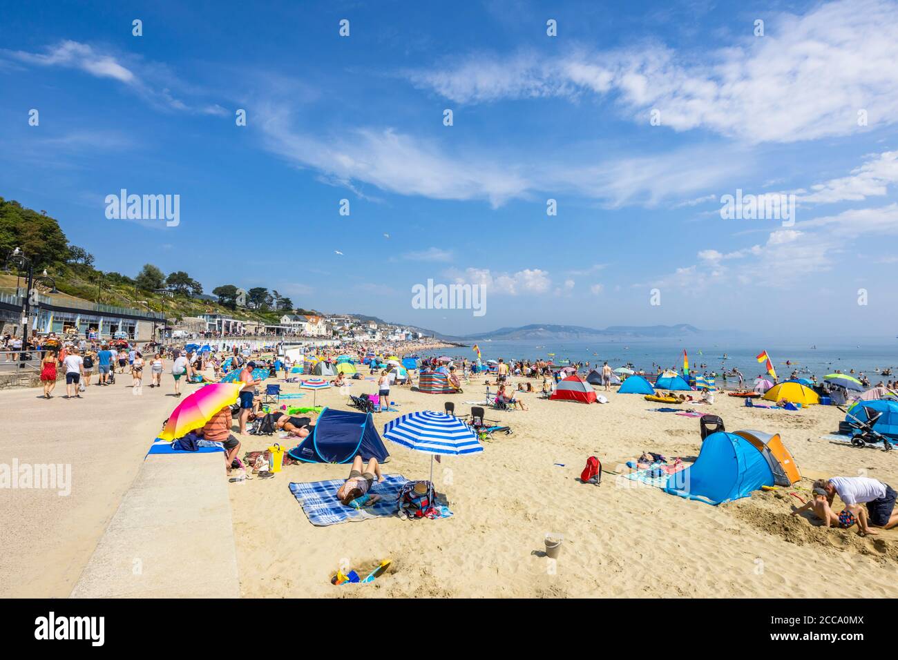 The crowded beach and seafront in high season at Lyme Regis, a popular seaside holiday resort on the Jurassic Coast in Dorset, south-west England Stock Photo