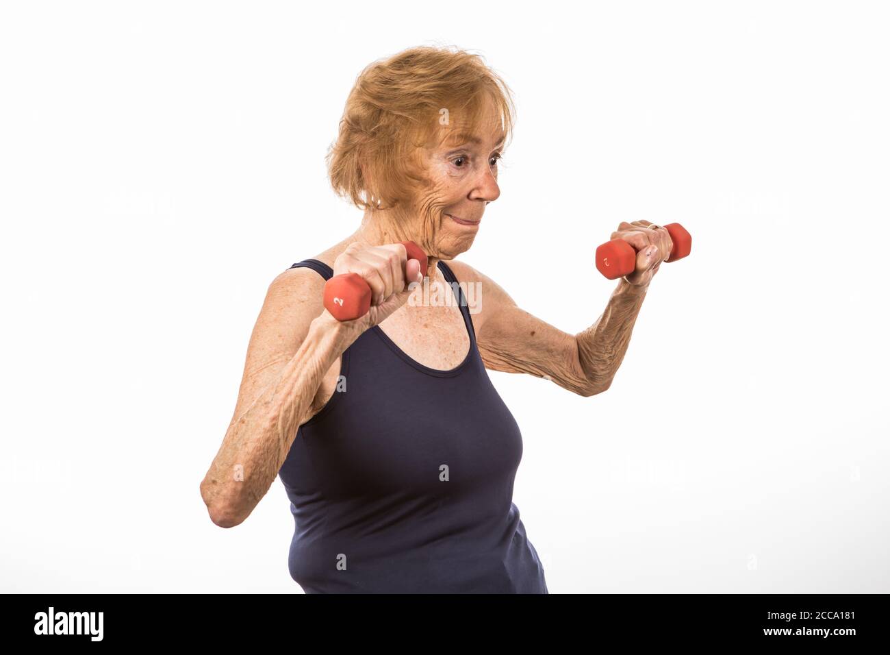 Senior Woman Concentrating On Lifting Two Pound Dumbbells Stock Photo