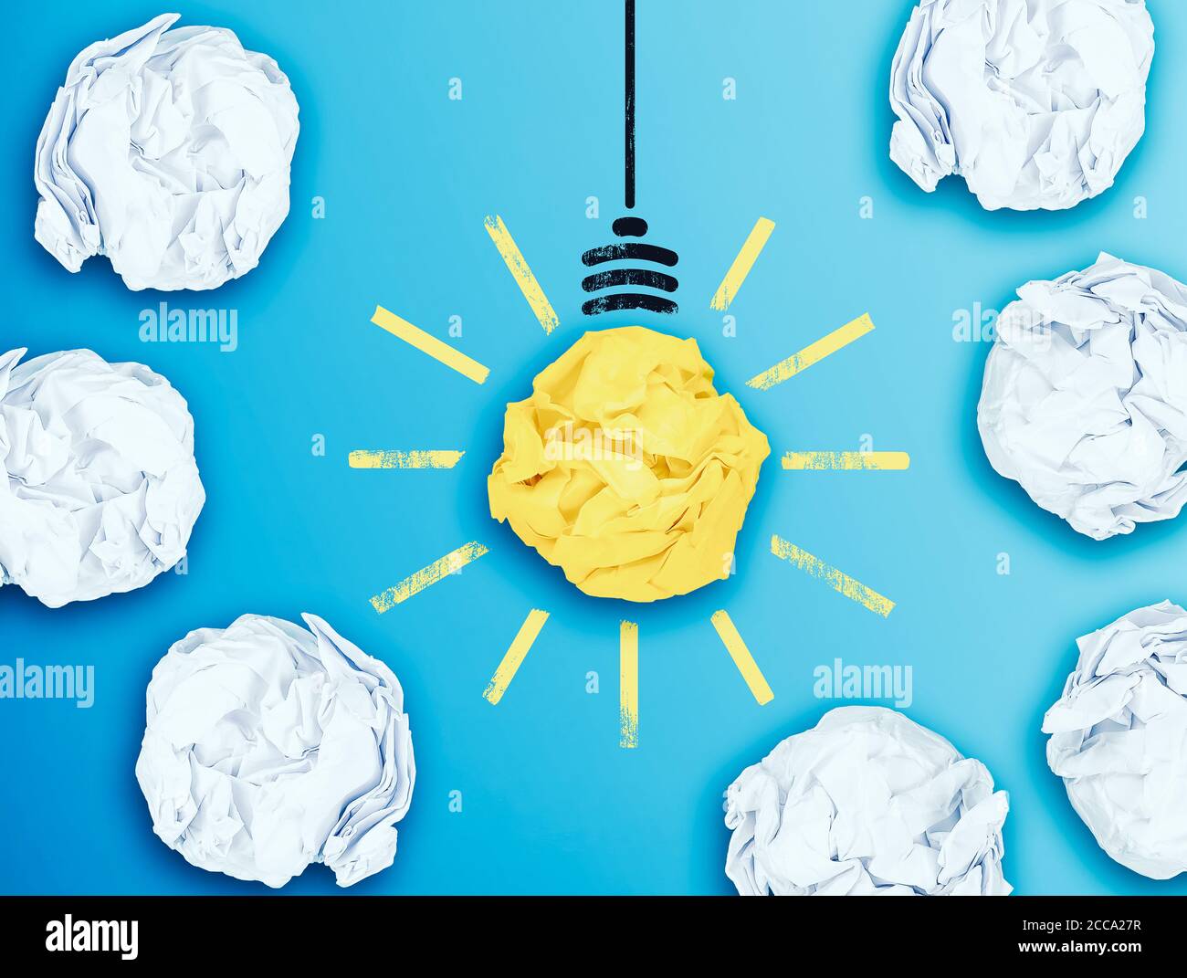 illuminated light bulb in midst of crumpled paper balls, having an idea concept Stock Photo