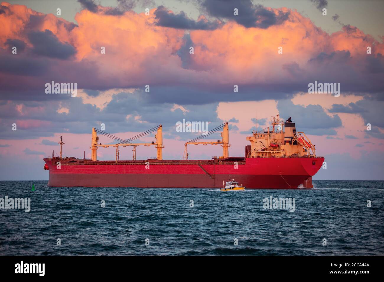 Sun setting at the sea with sailing cargo ship, scenic view Stock Photo ...