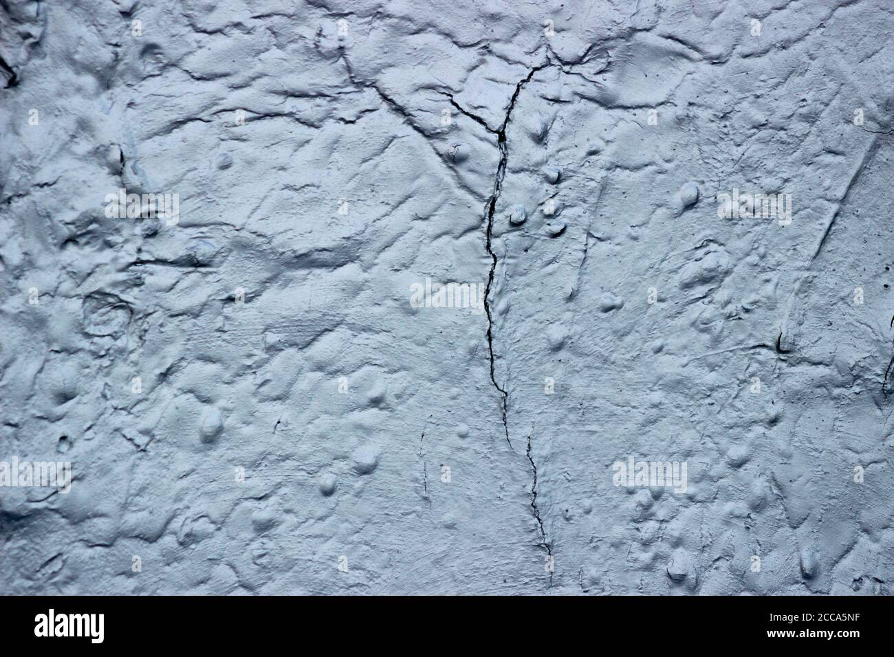 Aging, peeling, cracking, heatreflective paint on an exterior wall