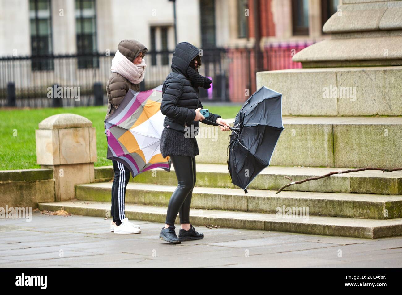 People battle the weather in Parliament Square in London during high winds and rain caused by Storm Ciara Stock Photo