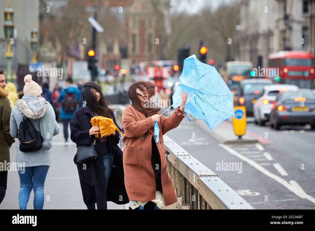 People battle the weather on Westminster Bridge in London during high winds and rain caused by Storm Ciara Stock Photo