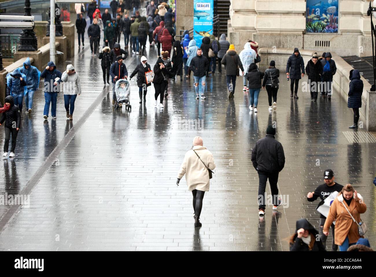 People battle the weather on the South Bank in London during high winds and rain caused by Storm Ciara Stock Photo