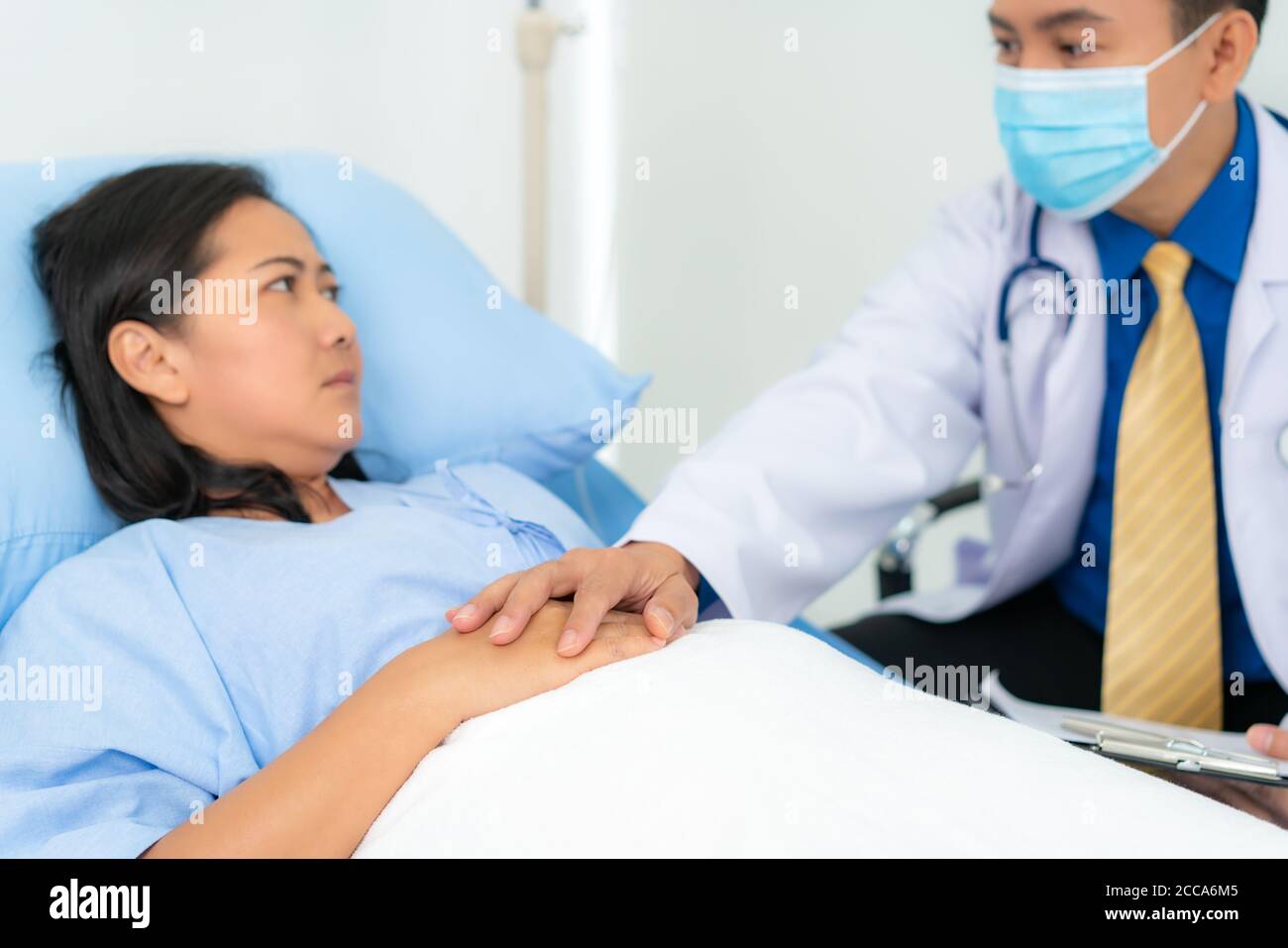 Close up of man doctor touching patient hand for encouragement and empathy on the hospital, cheering and support patient, Bad news, medical examinatio Stock Photo