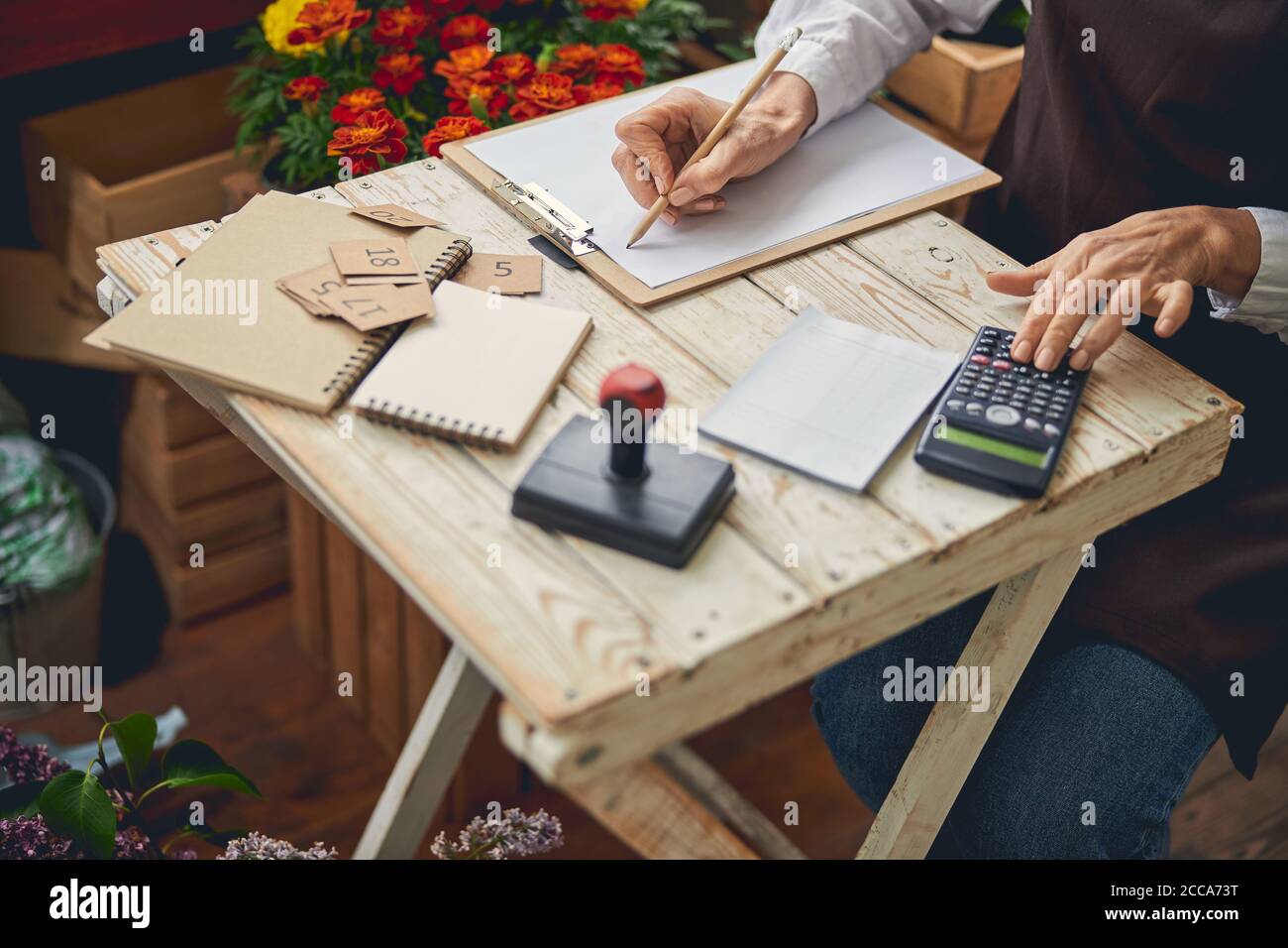Mature woman taking notes with a pencil Stock Photo - Alamy