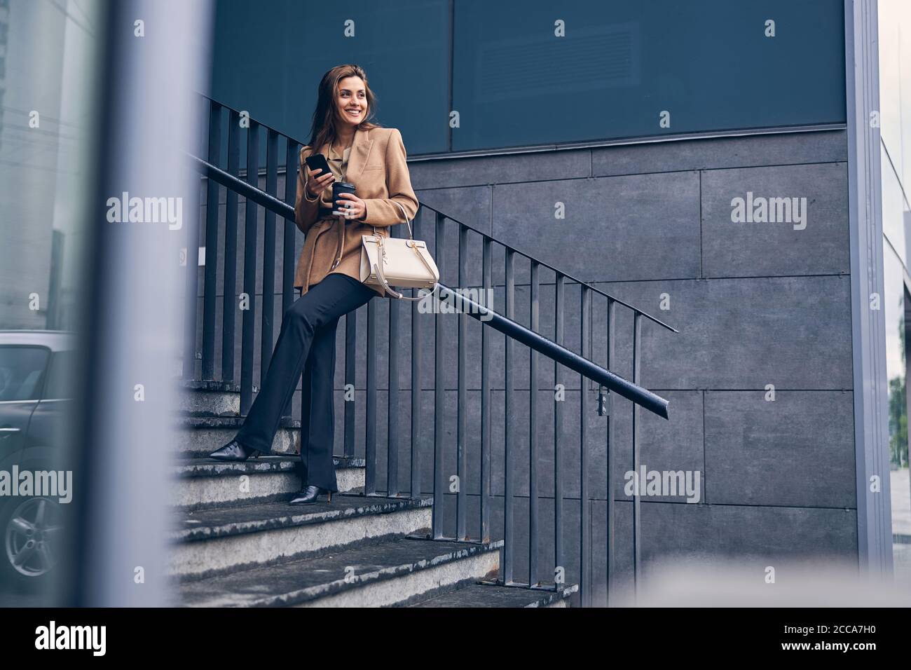 Smiling woman leaning back against the handrail Stock Photo
