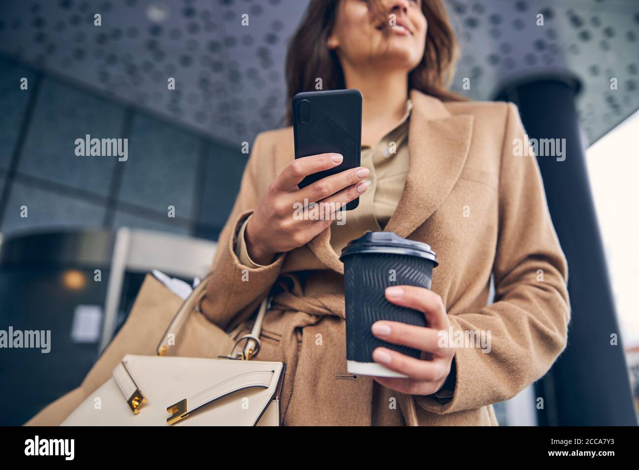 Pleased woman with a cellphone gazing into the distance Stock Photo