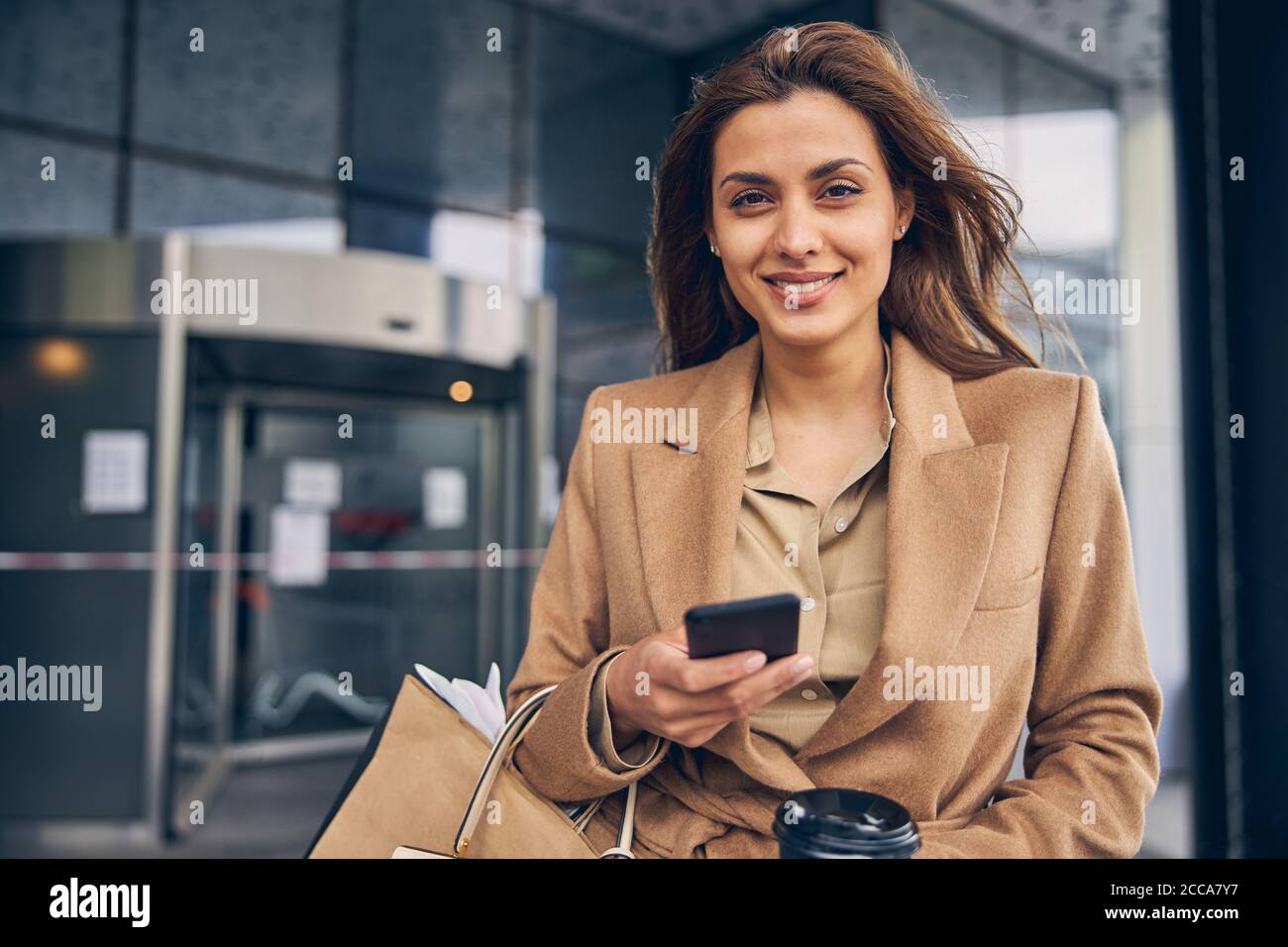 Smiling attractive stylish Caucasian woman standing outdoors Stock Photo