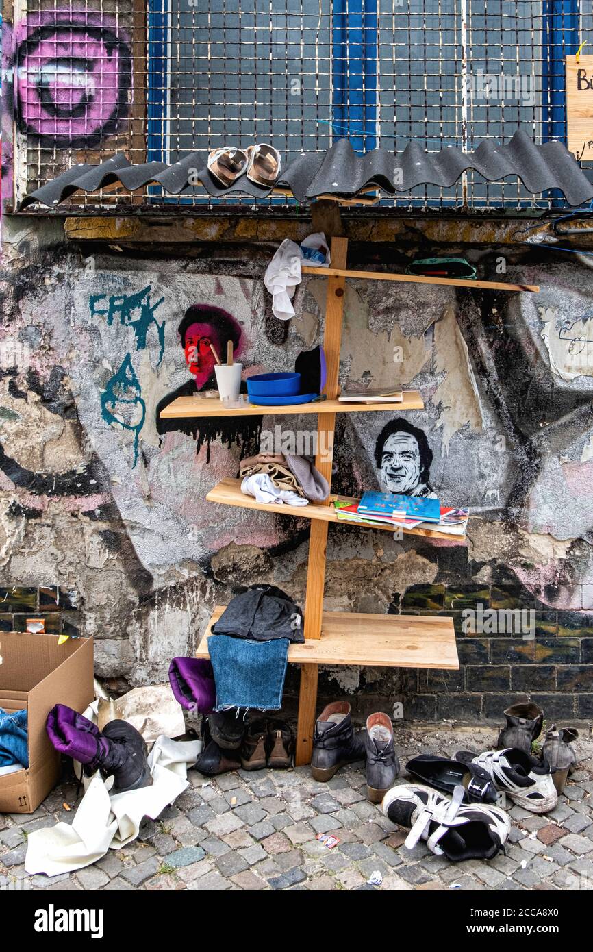 Berlin Mitte,Linienstrasse 206.Donations shelf - book exchange & clothes for needy during the Corona pandemic outside graffiti-covered Squat building Stock Photo