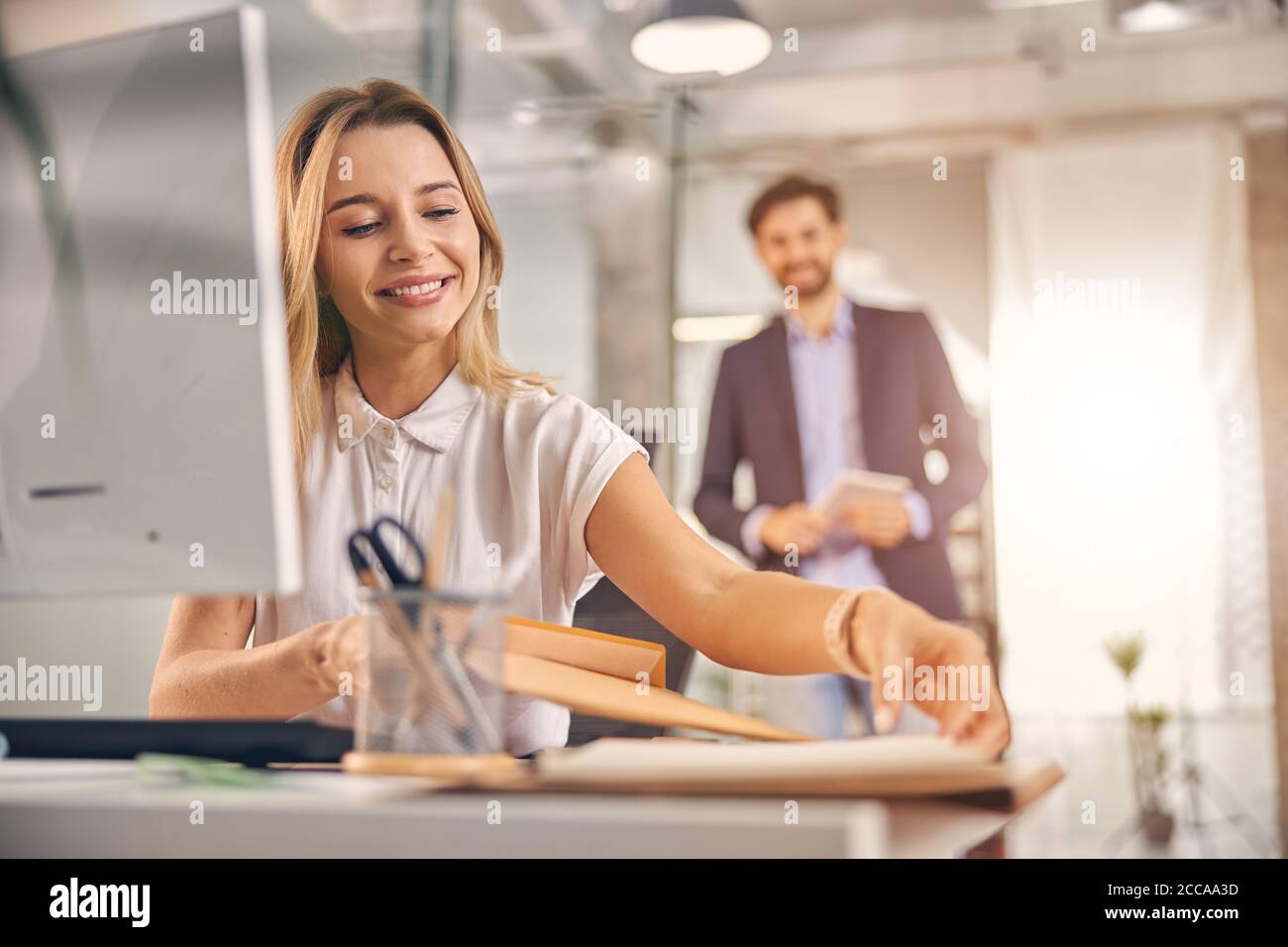 Charming young woman working in modern office Stock Photo
