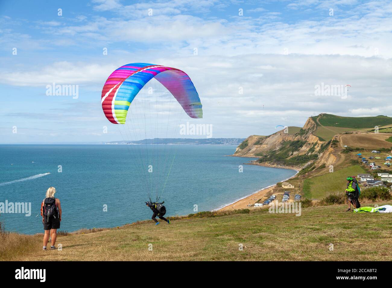 A Paraglider about to take off near Eype mouth beach along the South West Coast Path, on the Jurassic Coast, Dorset, England, UK Stock Photo