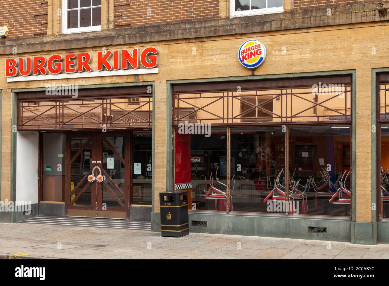 A closed burger king fast food restaurant with chairs on the tables in