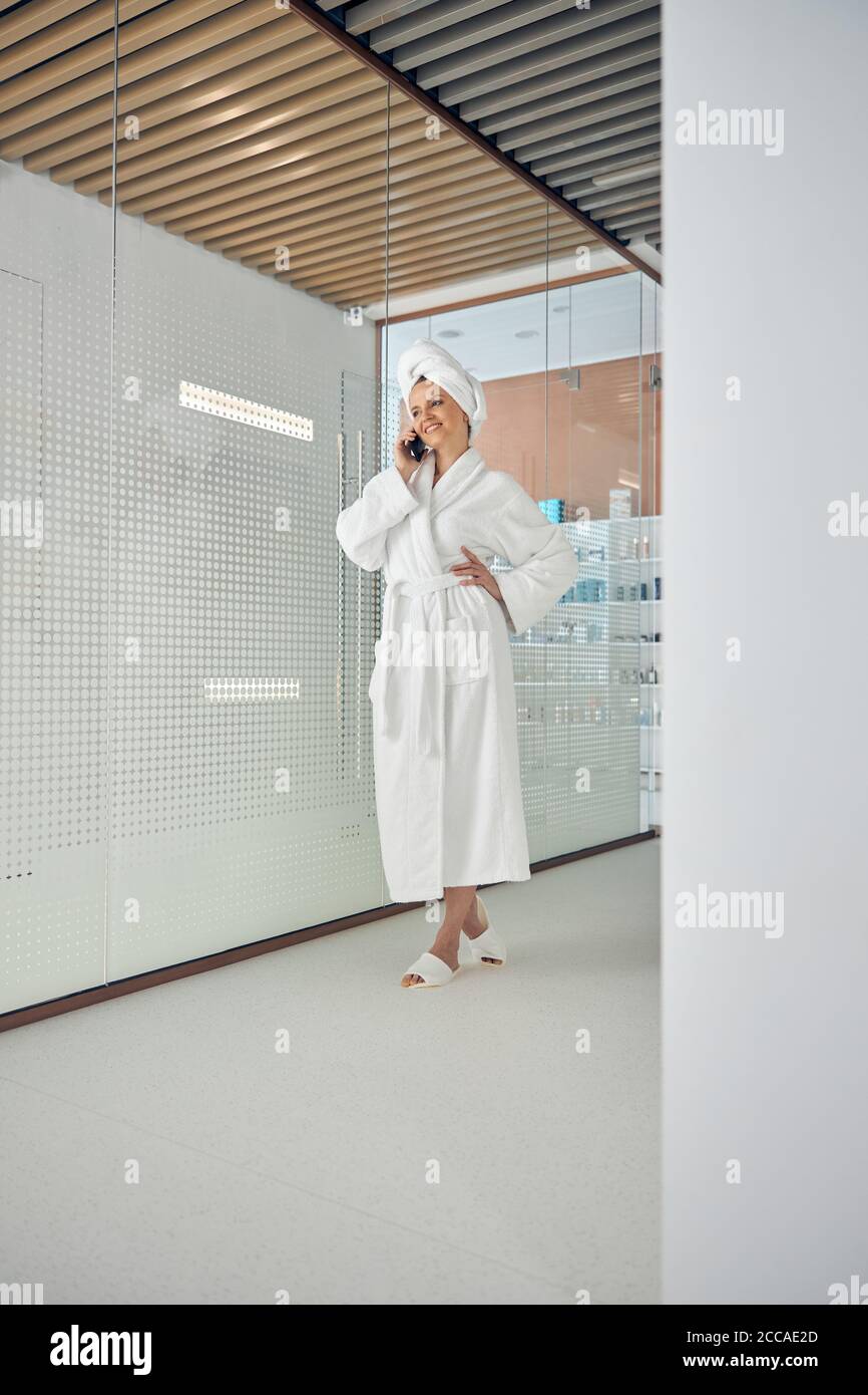 Smiling pleased spa client using her gadget Stock Photo