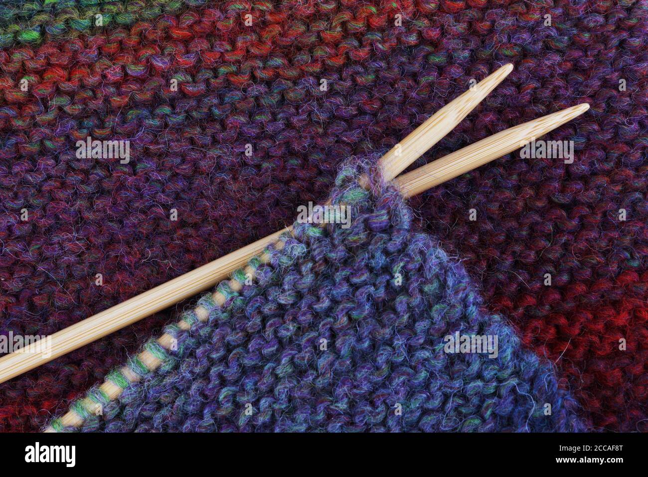 Knitting with wooden needles and colorful wool yarn Stock Photo