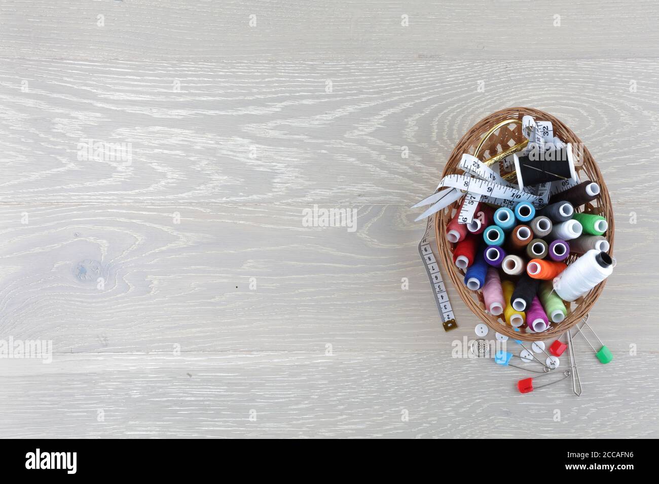 sewing basket on a wood surface with copy space Stock Photo