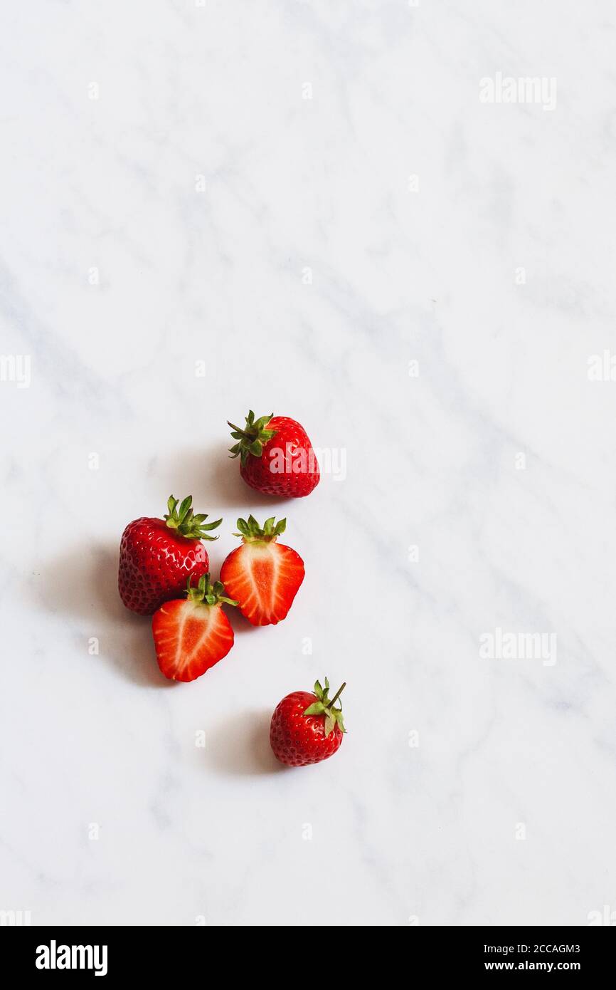 Summer fruit flatlay. Fresh strawberries on a white marble backdrop. Stock Photo