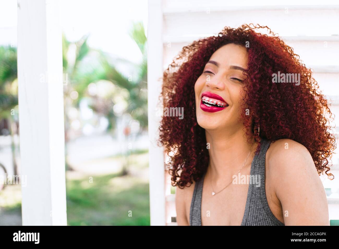 Beautiful Afro American woman with curly red hair laughing Stock Photo