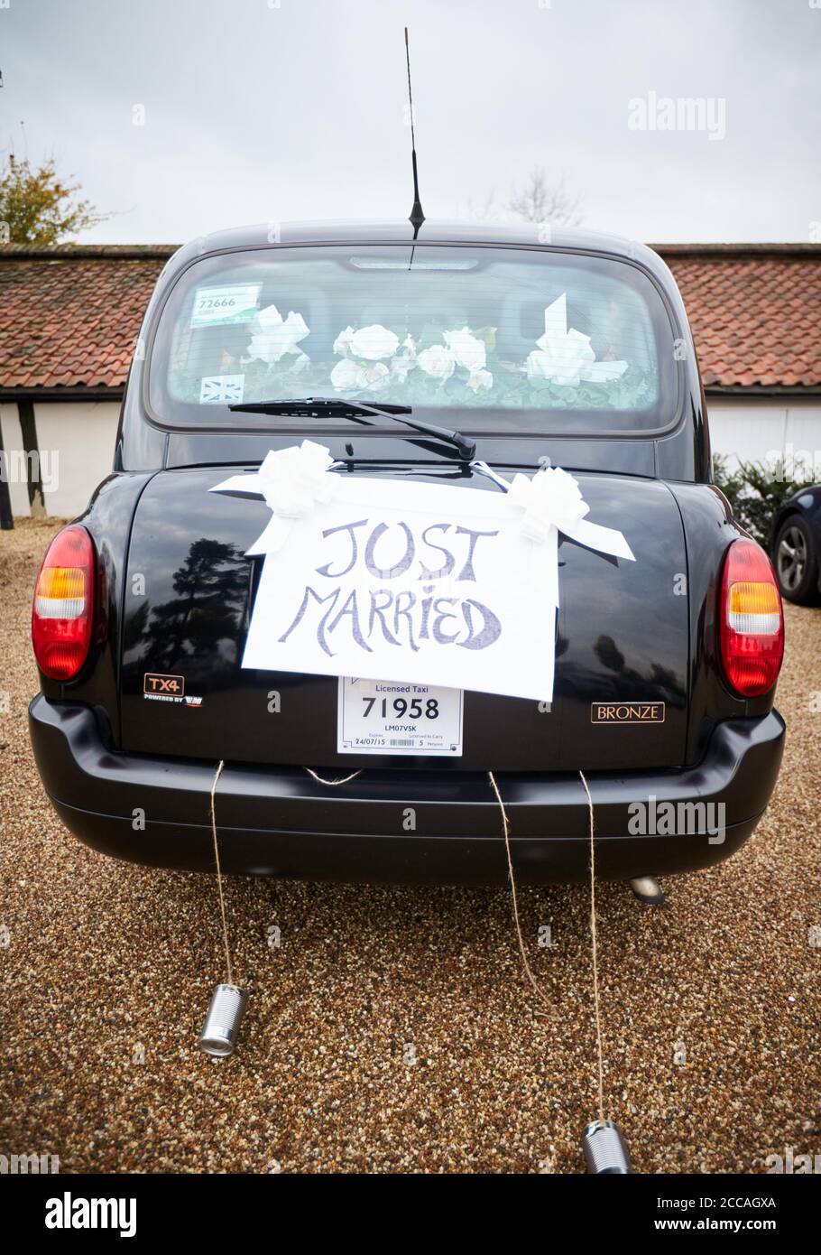 London black cab with a Just Married sign and tin cans tied to the bumper Stock Photo