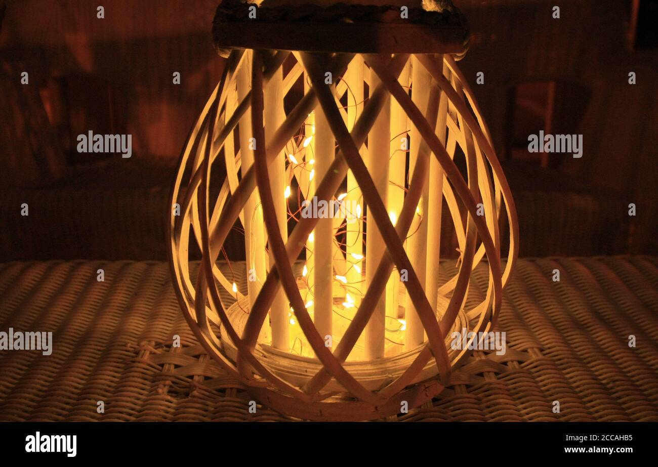 Glowing light at night on a wicker table. Stock Photo