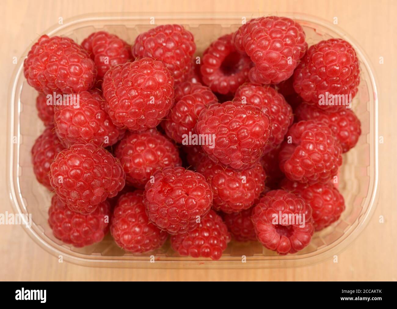 large ripe raspberries in a transparent plastic container Stock Photo ...