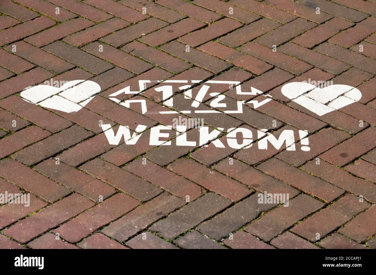 Kampen, The Netherlands, July 26, 2020: the 1,5 metre distance rule to prevent spreading of covid-19, painted in white on the pavement, with the word Stock Photo