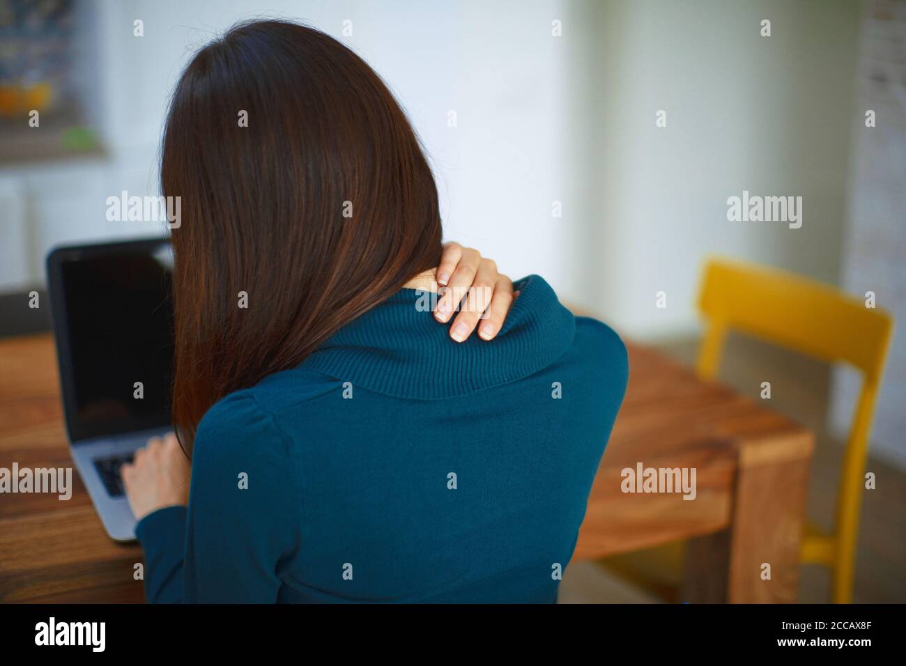 Close up of a brunette woman massaging her neck or shoulder. Stock Photo
