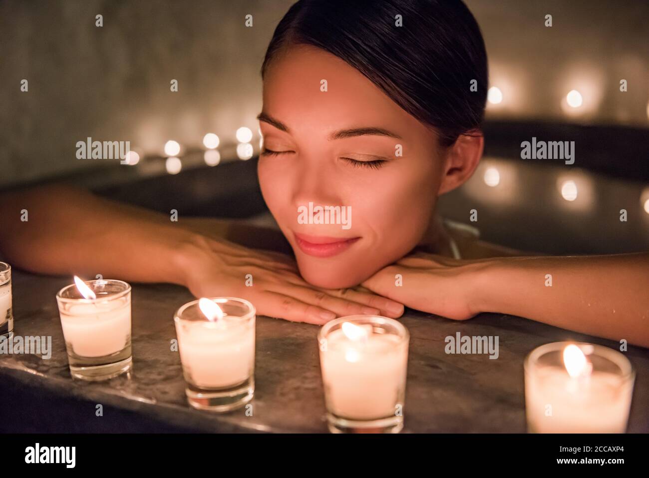 Beautiful young woman relaxing in jacuzzi hot tub at spa. Attractive female tourist is enjoying in water. Smiling woman with eyes closed is pampering Stock Photo