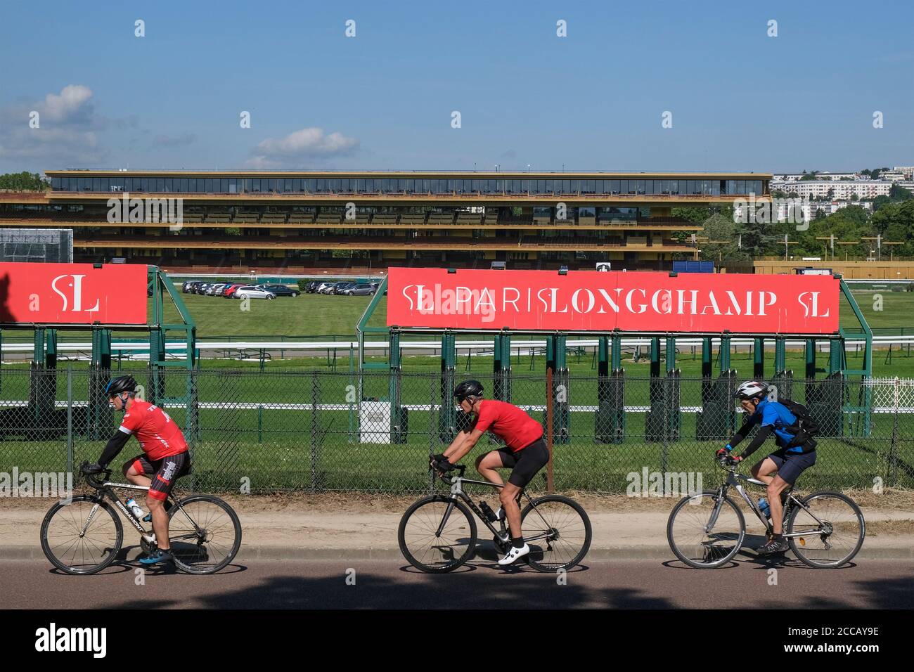 Three cyclist riding past Longchamp racecourse in Paris, France, Europe. Stock Photo