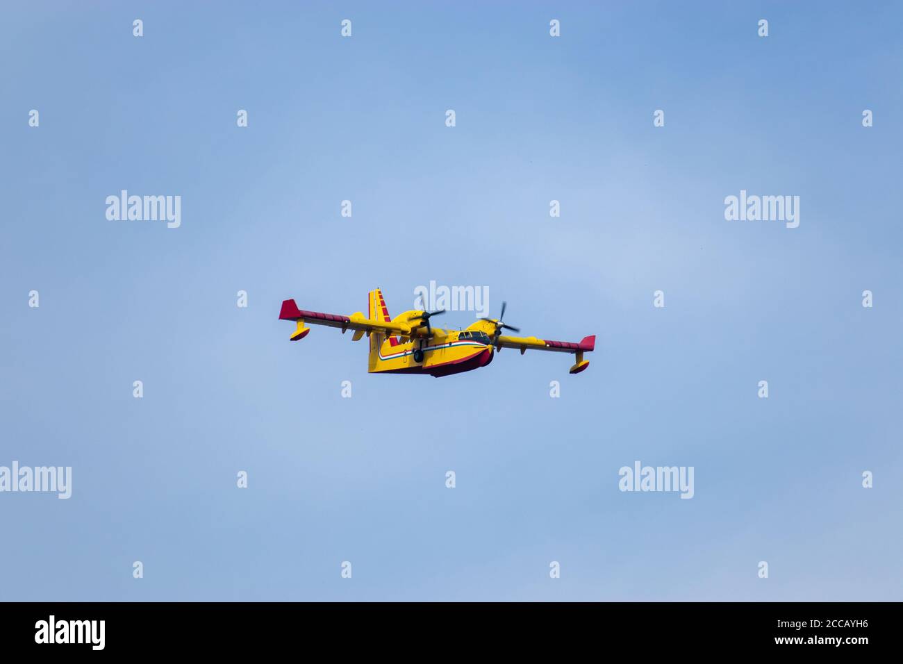 Close up of a fire fighting water bomber airplane flying over head, dropping water on wildfires