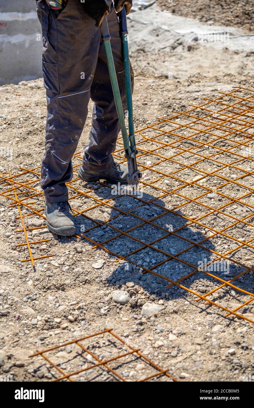 Construction worker with bolt cutter cutting steel bars. Cutting metal bar, scissors for