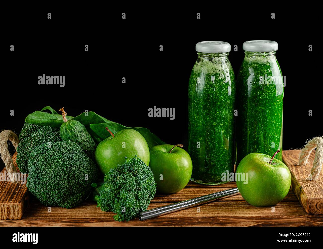 Bottles of green smoothie with ingredients on black background. Alkaline diet concept. Copy space Stock Photo