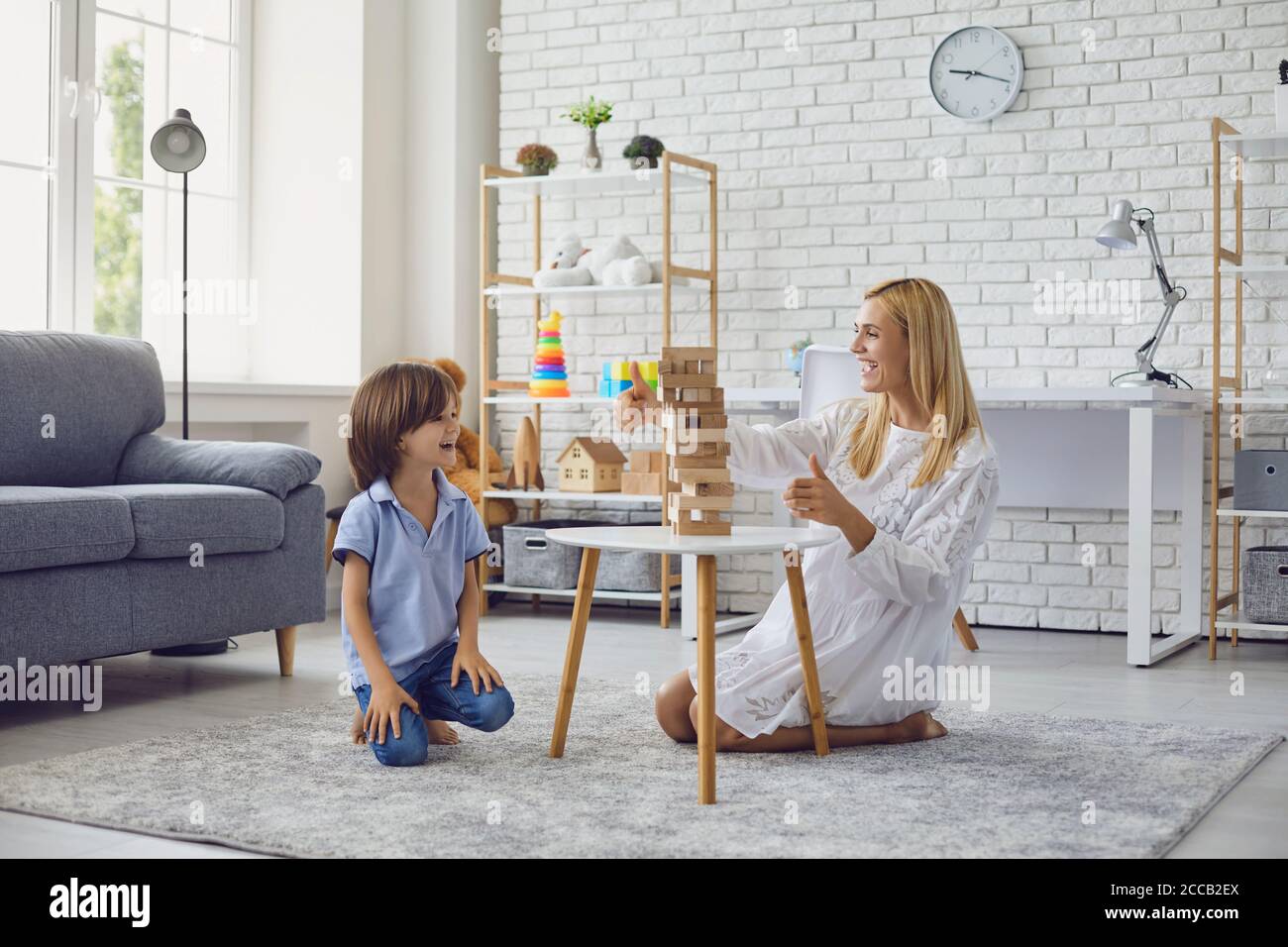 Mother and child have fun playing board games at home. Stock Photo