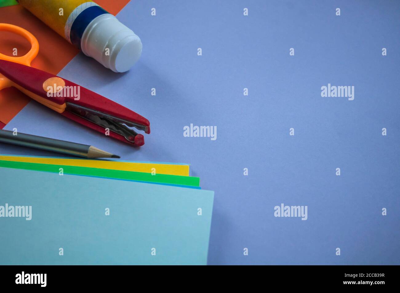 neatly laid out stationery along with a stack of other papers on blue