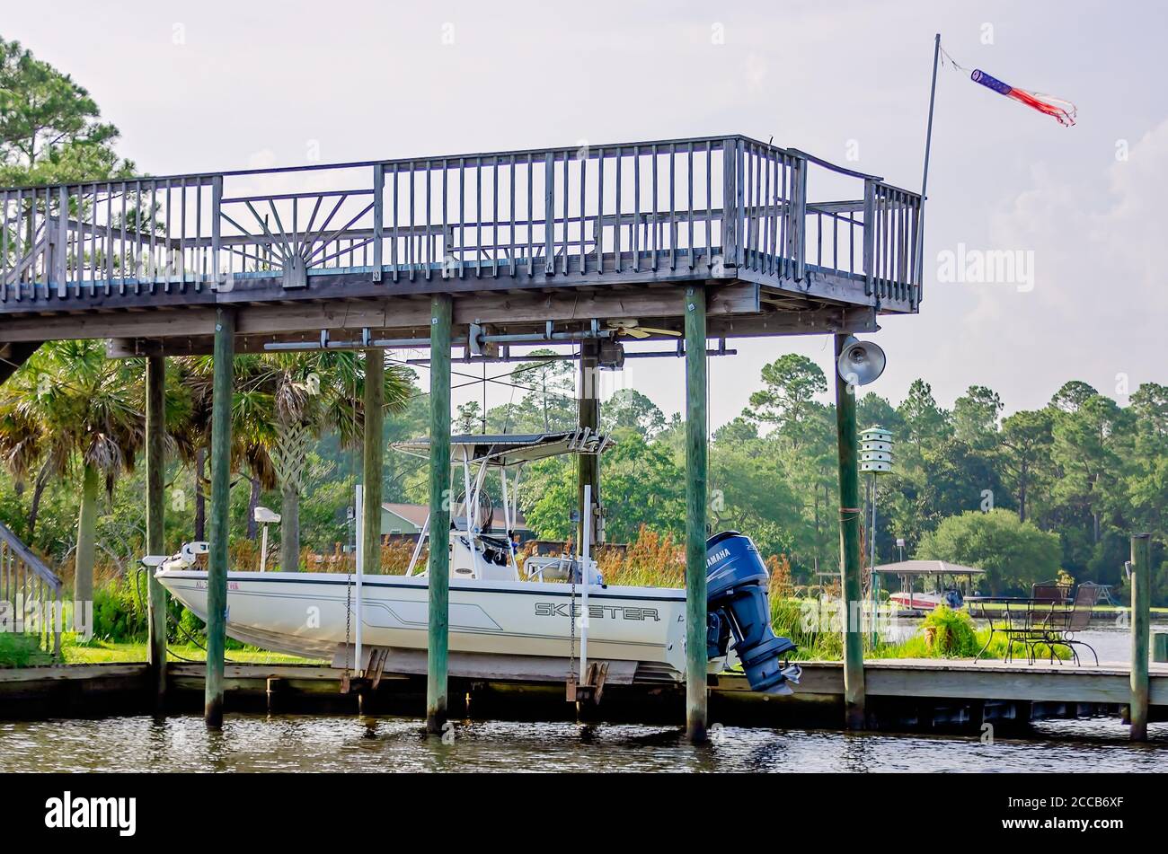 A saltwater fishing boat is suspended by a hydraulic lift beneath a dock while being stored, July 6, 2019, in Coden, Alabama. Stock Photo