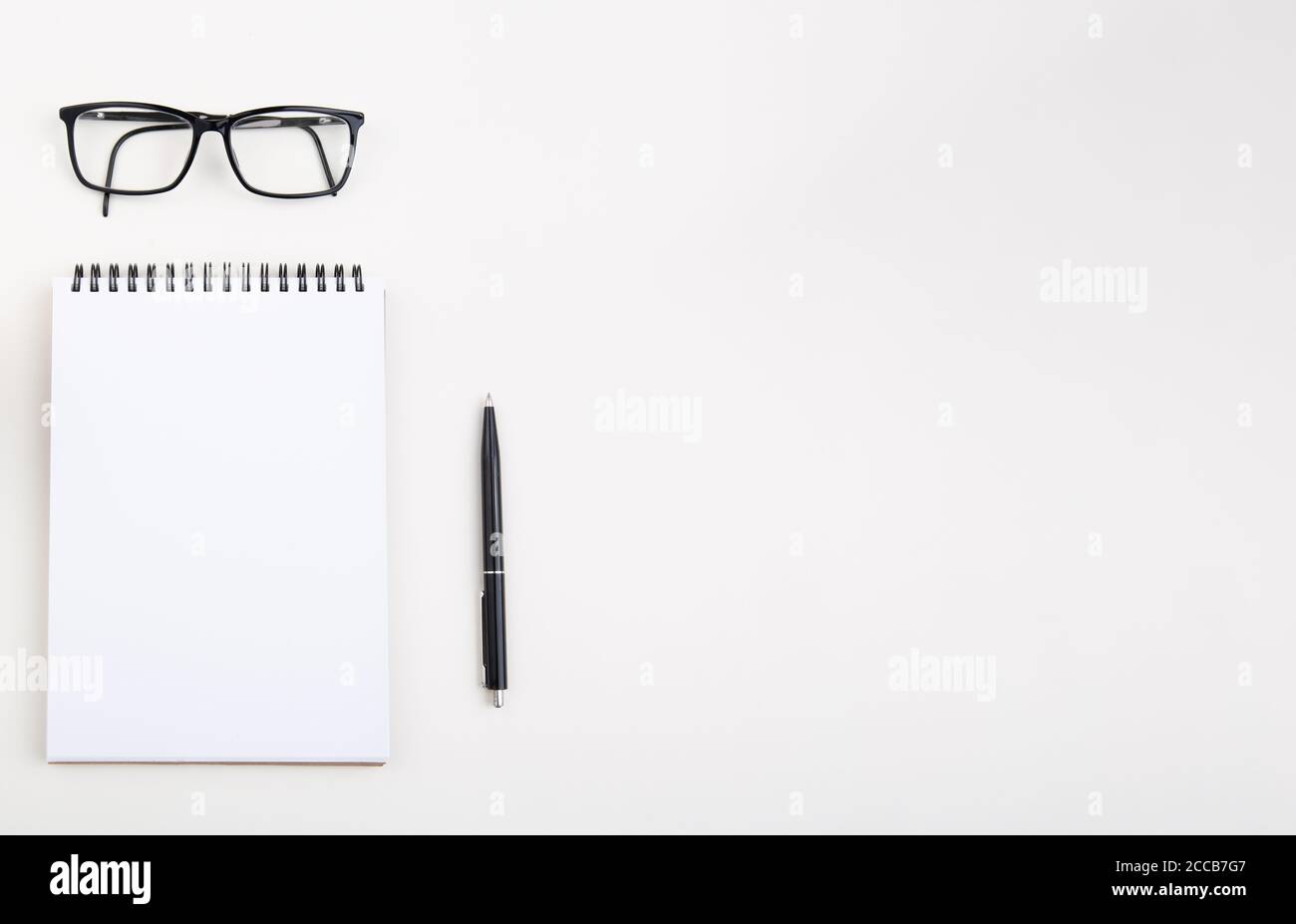 White notepad with black pen and glasses on light table,  Stock Photo