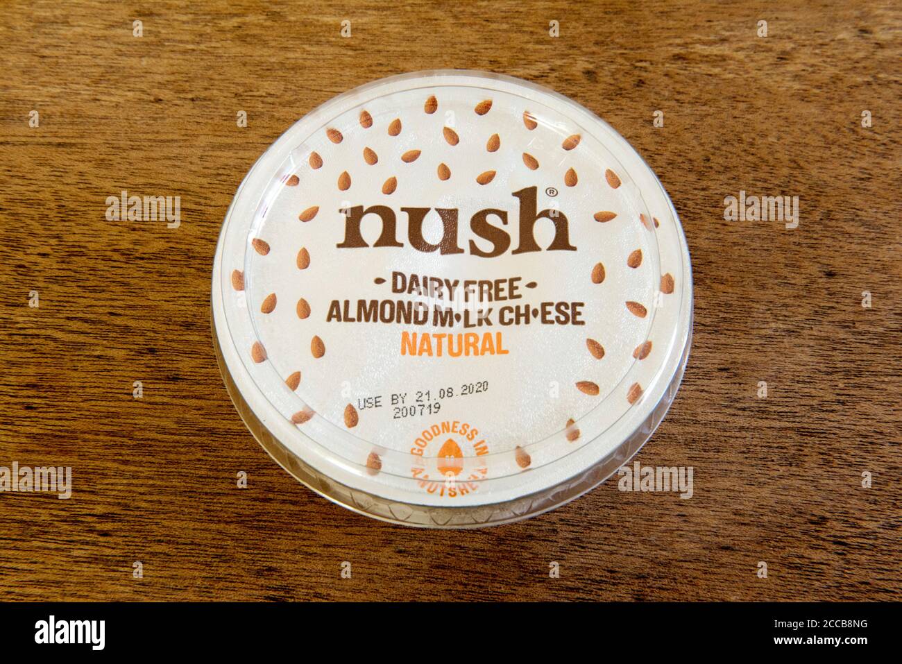 Nush dairy free almond milk cheese natural in tub or carton on wooden