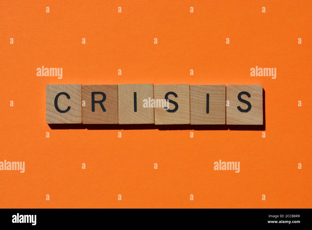 Crisis, word in wooden alphabet letters isolated on orange background with copy space Stock Photo