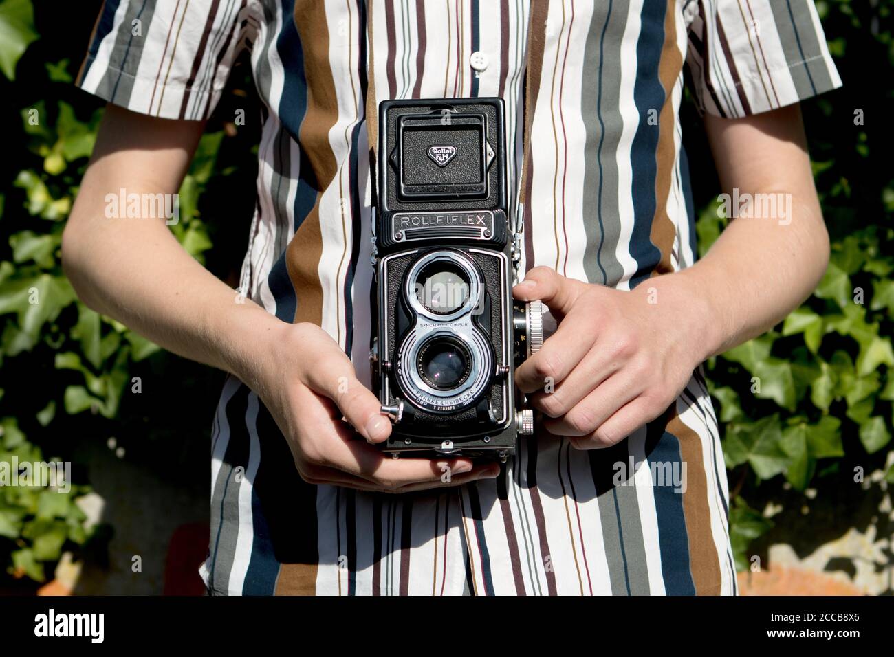 Rolleiflex twin reflex medium format vintage camera in front of a striped shirt Stock Photo