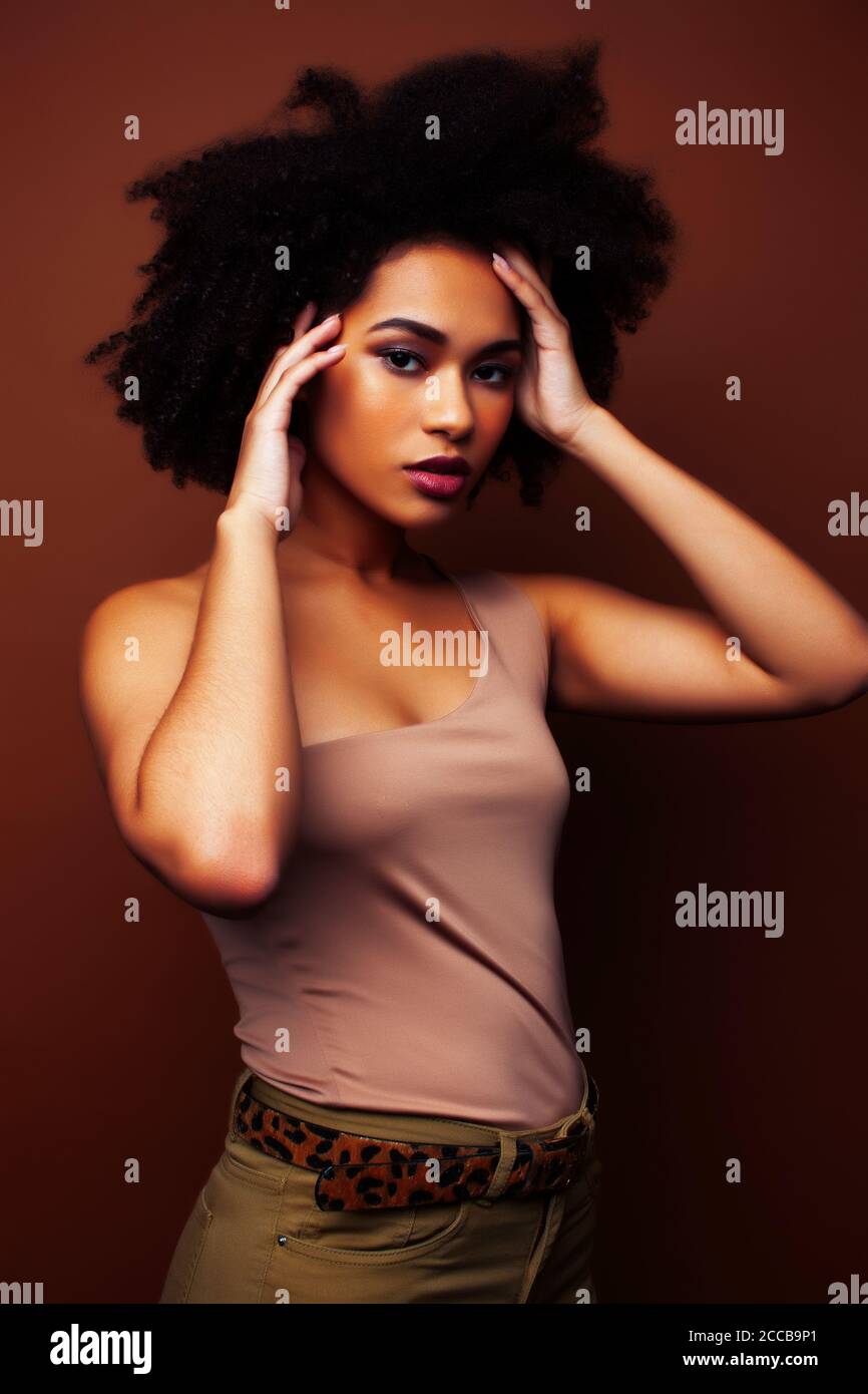 pretty young african american woman with curly hair posing cheerful ...