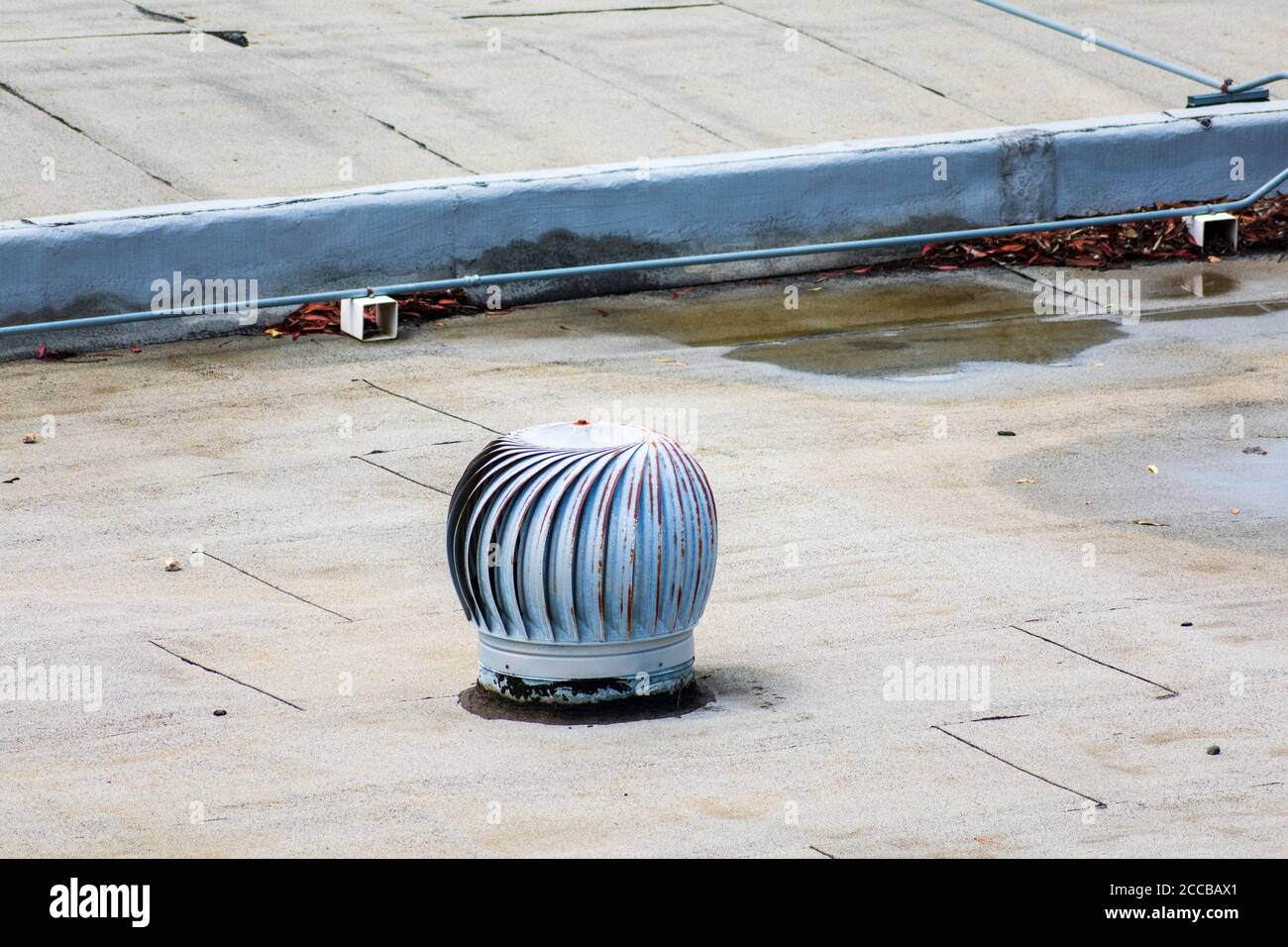 Weathered turbine vent on the flat roof in an industrial building