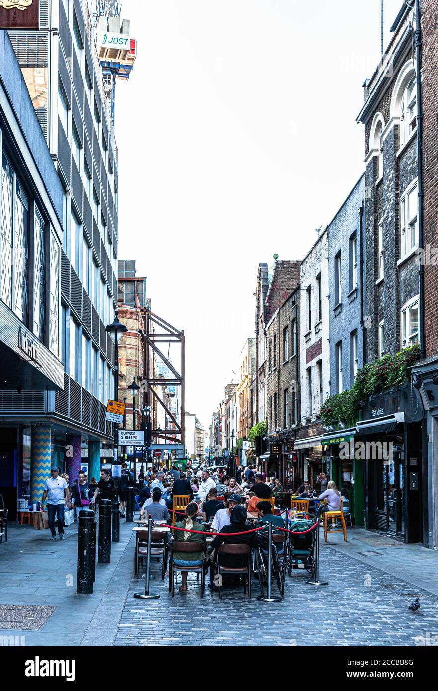 Customers dining al fresco on a pedestrianised street, Berwick Street, Soho, London, UK Stock
