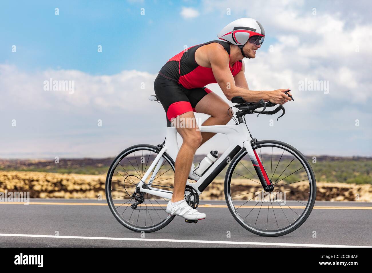 Triathlon cyclist man cycling racing on road bike on ironman competition racing against time
