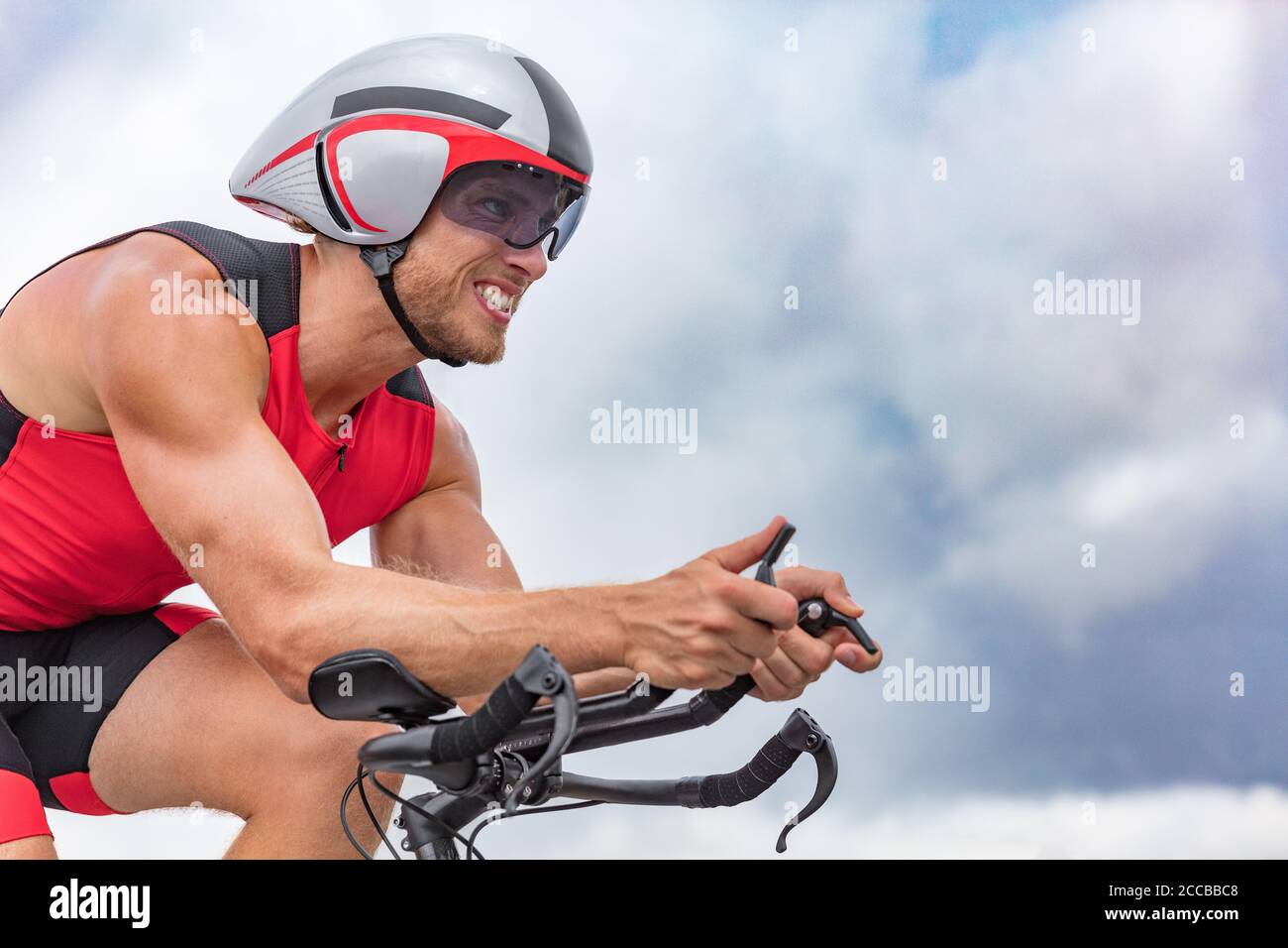 Triathlon biking man cyclist portrait riding bike. Male triathlete cycling on triathlon bike. Fit man professional athlete on triathlon bicycle Stock Photo