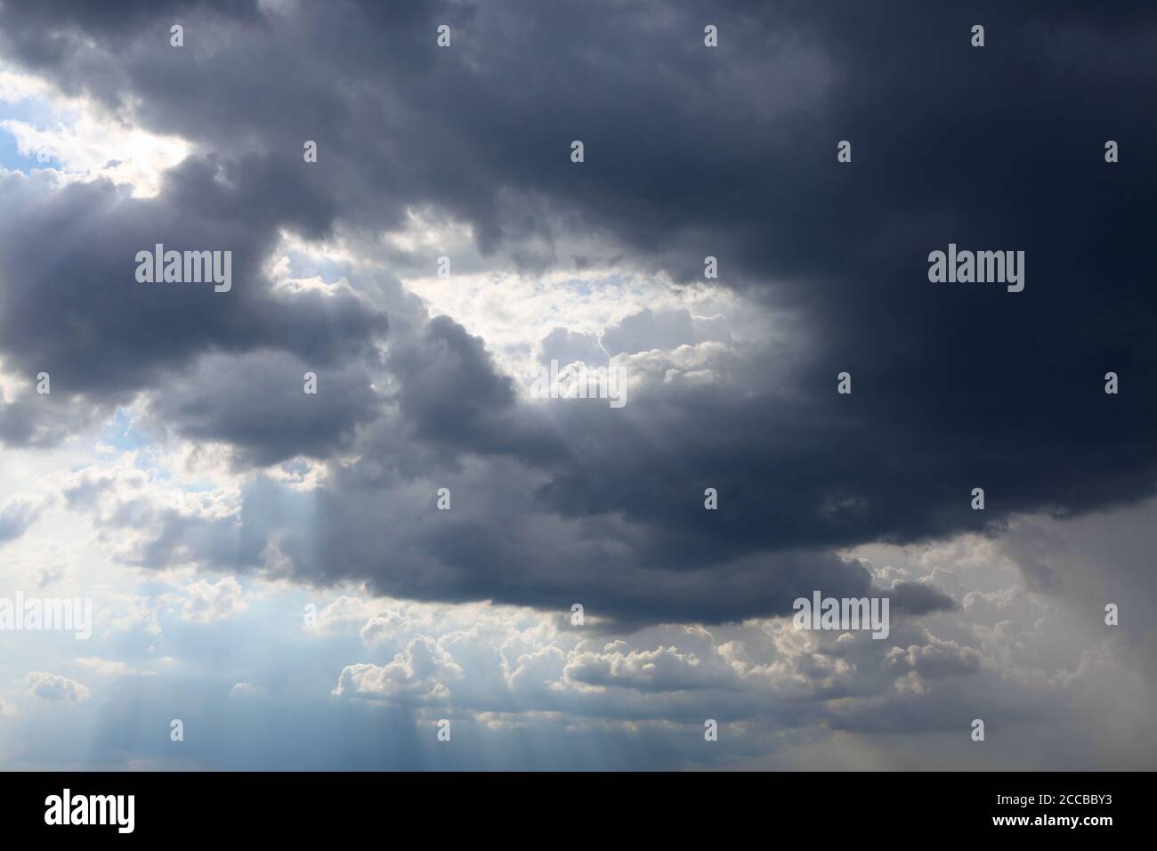 Hole in the sky . Black clouds with sunshine Stock Photo