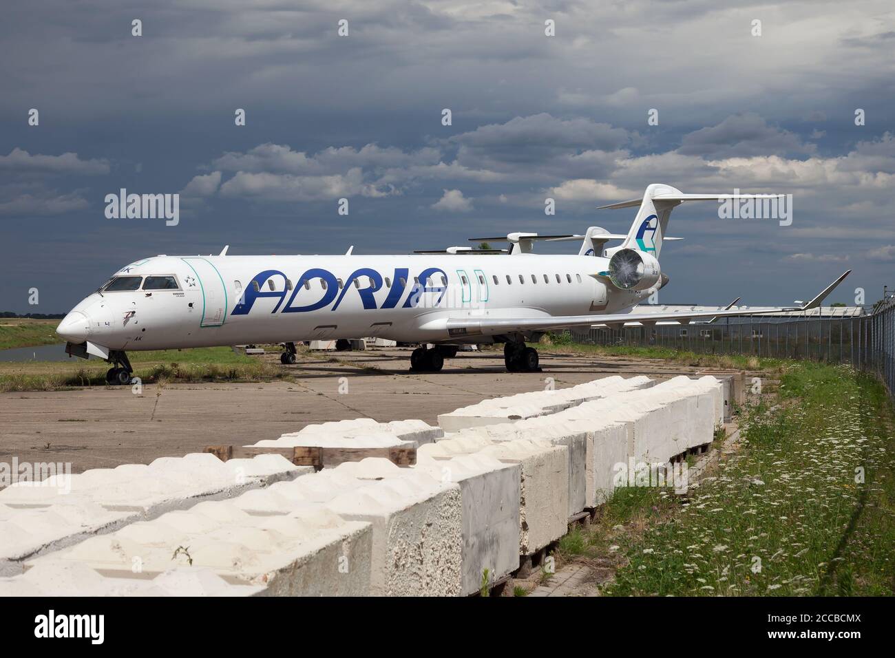 A Bombardier CRJ 900 previously belonged to Adria Airways now stored at  Maastricht-Aachen Airport. Stock Photo